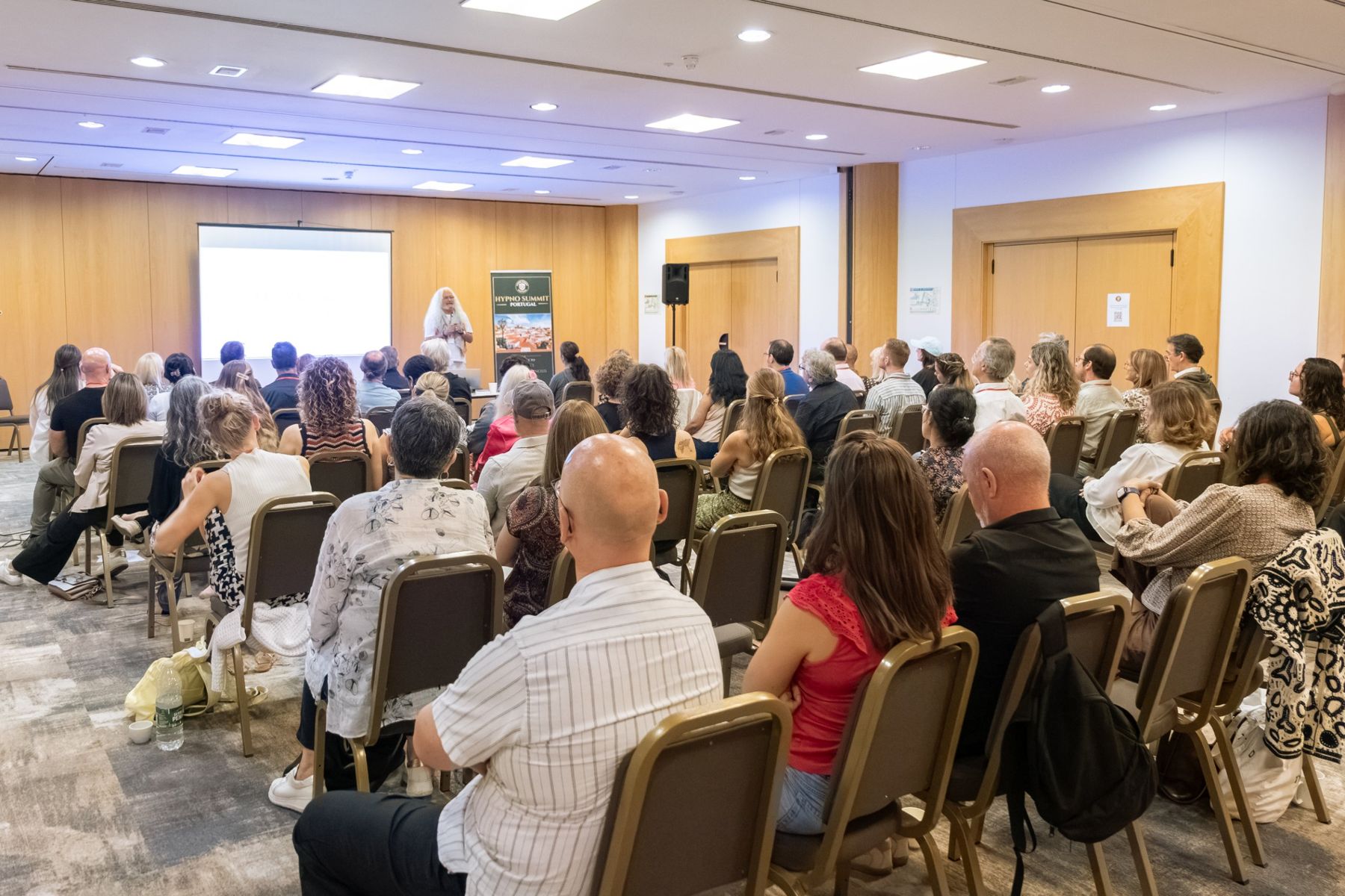 A speaker addressing a full room at Hypno Summit Portugal 2026
